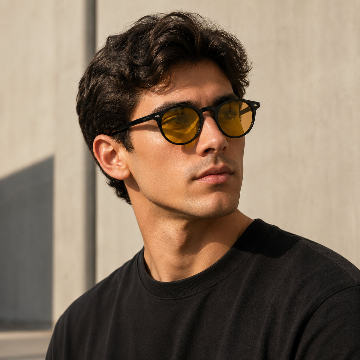 Homem usando óculos NOX Day preto com lentes amarelas e filtro de luz azul, em ambiente urbano com luz natural.