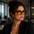 Mulher usando óculos Vesper Day preto com lentes amarelas de filtro de luz azul, em close-up dentro de um escritório moderno.