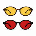 Óculos LUMA Kit apresentados em duas versões sobre fundo branco: armação Tortoise com lentes amarelas na parte superior para o Day e armação preta com lentes vermelhas na parte inferior para o Night, destacando o formato ovalado do modelo.